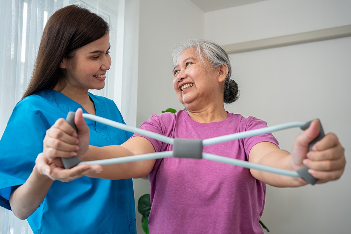Therapist supporting neurological rehabilitation with a resistance exercise